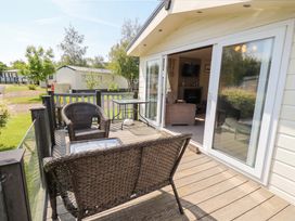 An outdoor patio area with chairs and a table at 41, Grandma's Cottage near South Lakeland Leisure Village near Carnforth