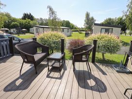 An outdoor seating area with chairs and a table at 41, Grandma's Cottage South Lakeland Leisure Village near Carnforth