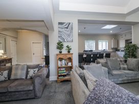 A living room with sofas and a bookshelf at Clarence House in Dalton-In-Furness