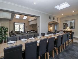 A dining room with a long table and chairs at Clarence House in Dalton-In-Furness