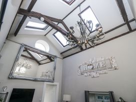 A living room with a chandelier and a large mirror at Clarence House in Dalton-In-Furness