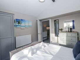 A bedroom with a bed, wardrobe, and mirror at Clarence House in Dalton-In-Furness