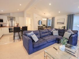 A living room with a sectional sofa and a dining area at Unique Luxury Lodge, 1 Langdale, White Cross Bay near Windermere