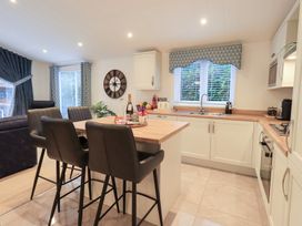 A kitchen with bar stools and a sink at Unique Luxury Lodge 1 Langdale, White Cross Bay near Windermere