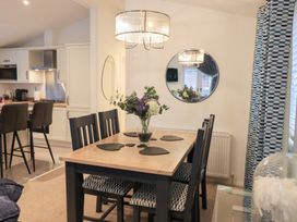 A dining room with a table and chairs at Unique Luxury Lodge 1 Langdale, White Cross Bay near Windermere