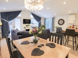 A living room with a sofa and dining table at Unique Luxury Lodge, 1 Langdale, White Cross Bay near Windermere