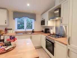 A kitchen with a sink, oven, and cabinets at Unique Luxury Lodge, 1 Langdale, White Cross Bay near Windermere