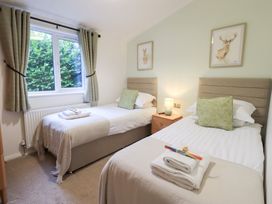 A bedroom with twin beds and a bedside table at Unique Luxury Lodge 1 Langdale, White Cross Bay near Windermere