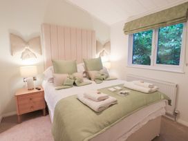 A bedroom with a bed and nightstand at Unique Luxury Lodge, 1 Langdale, White Cross Bay near Windermere
