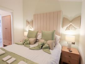 A bedroom with a bed, bedside table, and wardrobe at Unique Luxury Lodge, 1 Langdale, White Cross Bay near Windermere