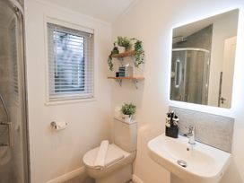 A bathroom with a shower, toilet, and sink at Unique Luxury Lodge, 1 Langdale, White Cross Bay near Windermere