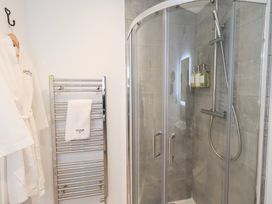A shower with glass doors and a towel rack at Unique Luxury Lodge, 1 Langdale, White Cross Bay near Windermere