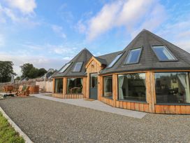 A house exterior with large windows and deck chairs at Ty Crwn in Lampeter