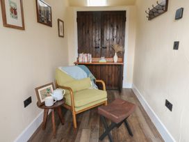 A snug area with a chair and table at Ty Crwn in Lampeter