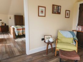 A living room with a chair and teapot at Ty Crwn in Lampeter