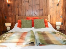 A bedroom with a wooden bed and pillows at Ty Crwn in Lampeter