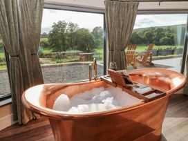 A bathroom with a copper bathtub and a view at Ty Crwn Lampeter