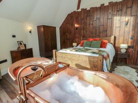 A bedroom with a bathtub and a bed at Ty Crwn in Lampeter