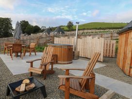 An outdoor area with seating, hot tub, and fire pit at Ty Crwn in Lampeter