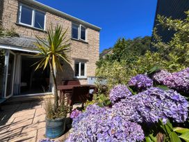 A garden with flowers and seating area at Foxglove Cottage in Falmouth