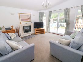 A living room with a sofa and television at Serenity in Kilgetty