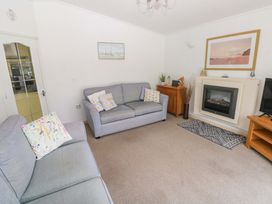 A living room with a sofa and a television at Serenity in Kilgetty