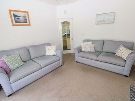 A living room with two sofas and a door at Serenity in Kilgetty