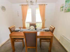 A dining room with a wooden table and chairs at Serenity in Kilgetty