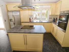 A kitchen with an island, sink, and refrigerator at Serenity in Kilgetty