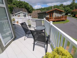 A outdoor patio with a table and chairs at Serenity in Kilgetty