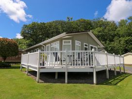 A house with a deck and surrounding trees at Serenity Stepaside near Kilgetty
