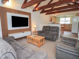 A living room with a sofa and television at Whitbarrow 24 Penruddock