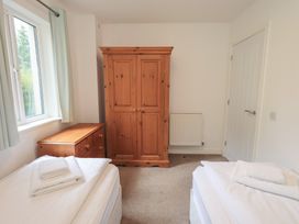 A bedroom with two beds and a wardrobe at Whitbarrow 24 in Penruddock