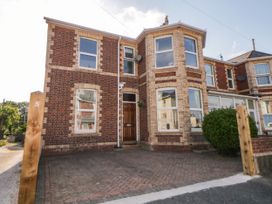 A brick house with bay windows and a paved driveway at 5 Stafford Road in Paignton