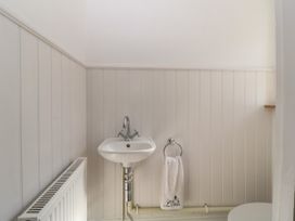 A bathroom with a wall-mounted sink towel ring with a towel and a radiator at 5 Stafford Road Paignton