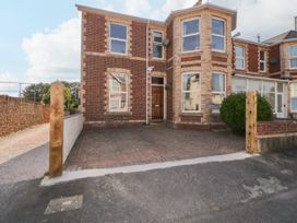 A brick house with bay windows and a paved driveway at 5 Stafford Road in Paignton