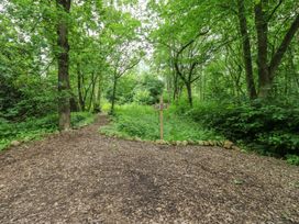 A pathway leading to a car park sign in a wooded area at The Leveret Eppleby