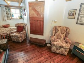 A living room with armchairs and a wooden bench at Penfeidr Newydd, Carningli Common, Newport, Pembrokeshire