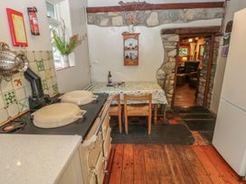 A kitchen with stove and dining table at Penfeidr Newydd, Carningli Common, Newport, Pembrokeshire