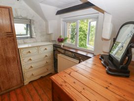 A bedroom with a dresser, mirror and window at Penfeidr Newydd, Carningli Common, Newport, Pembrokeshire