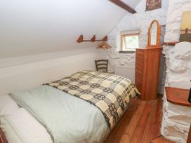 A bedroom with a bed and dresser at Penfeidr Newydd in Carningli Common, Newport, Pembrokeshire