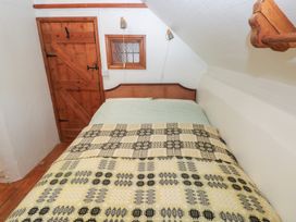 A bedroom with a bed and wood door at Penfeidr Newydd, Carningli Common, Newport, Pembrokeshire
