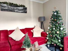 A living room with a Christmas tree and a sofa at The Paddock in Keswick