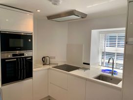 A kitchen with an oven, kettle, sink, and stovetop at Beach Cottage in Cadgwith