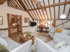 A living room with a sofa and television at The Cow Shed in Chediston near Halesworth