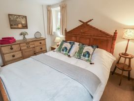 A bedroom with a bed and dresser at The Cow Shed in Chediston near Halesworth