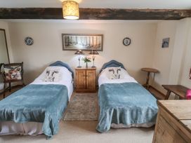 A bedroom with twin beds and a wooden table at The Cow Shed in Chediston near Halesworth