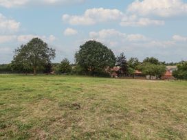 An outdoor view with trees and buildings at The Cow Shed in Chediston near Halesworth