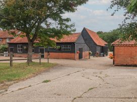 An outdoor view of multiple buildings and a tree at The Cow Shed in Chediston near Halesworth