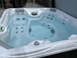 A hot tub filled with water in an outdoor area at Riviere House Hayle